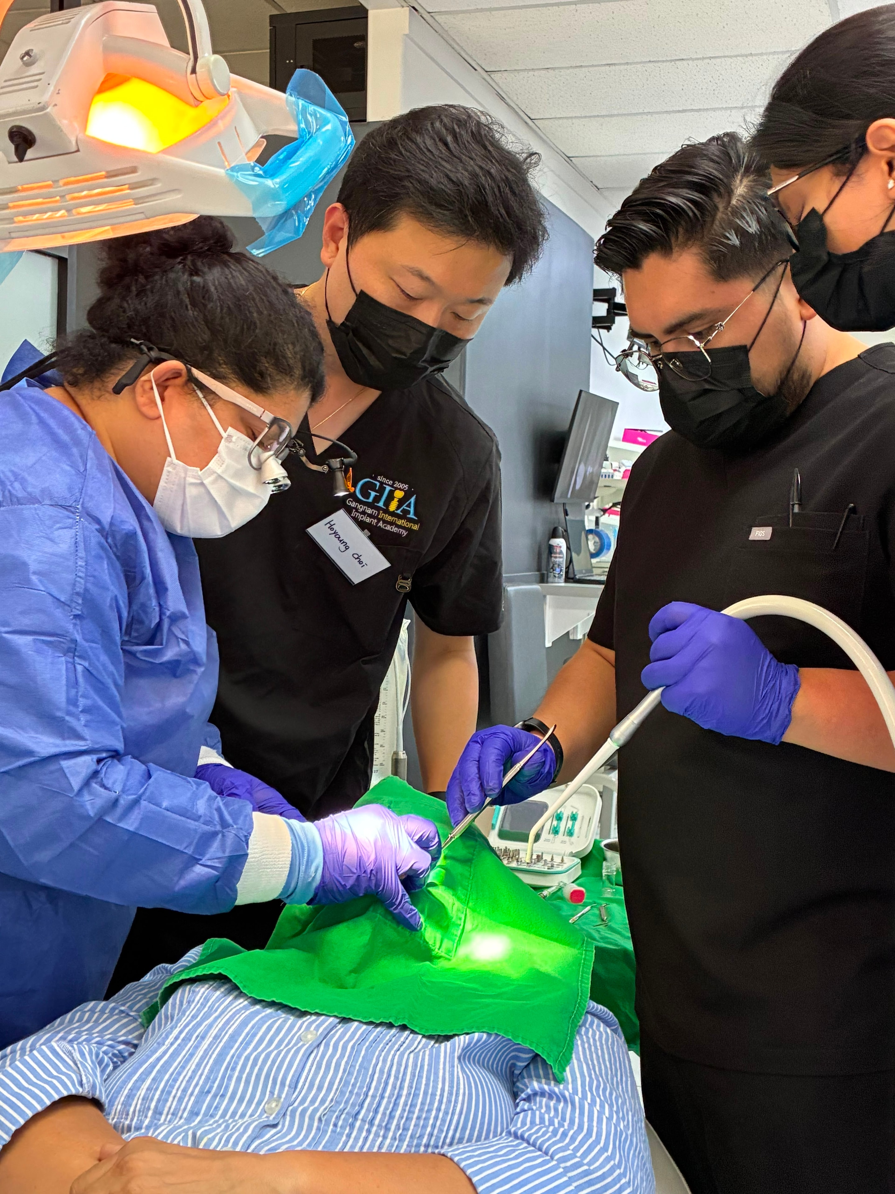 Dental professionals performing live implant surgery during the five-day implant course