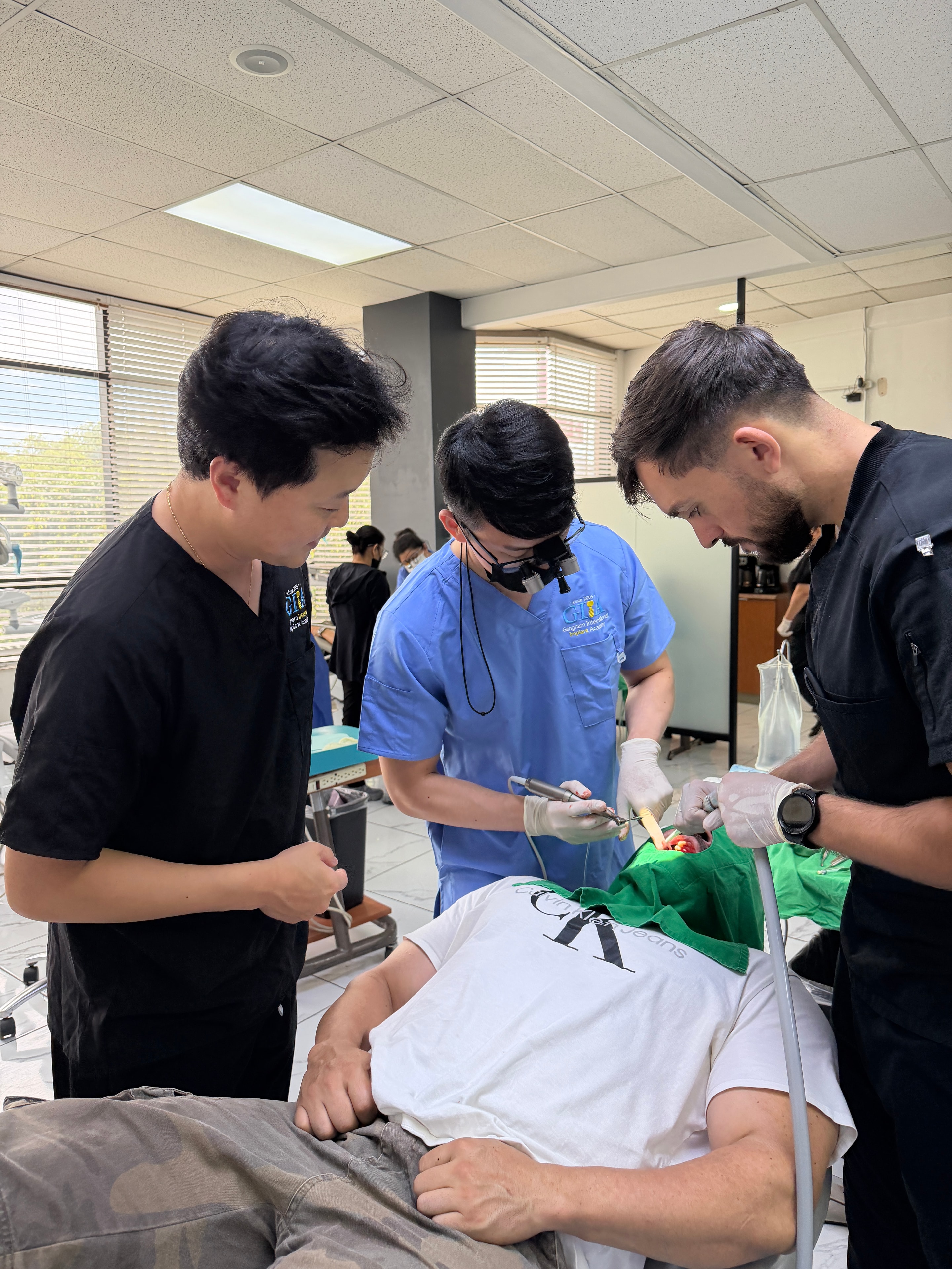 Dental professionals performing implant surgery during the live surgery course